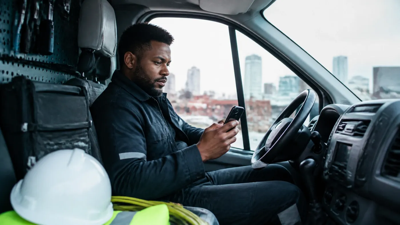 Mobile field-service technician in a service van viewing a live invoice and cash dashboard